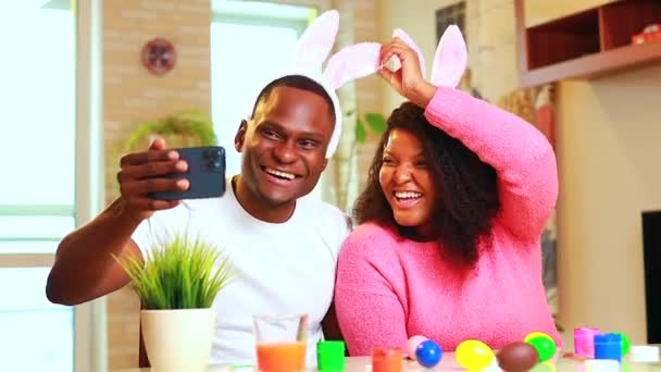 Uomo afro-americano che si prepara per la Pasqua in appartamento chiamando alla famiglia per telefono videochiamata — Video Stock