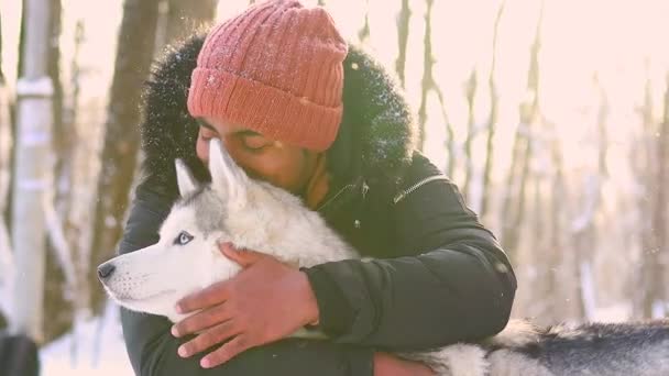 Mieszane wyścig człowiek przytulić jego pies husky w zimie Forest Park — Wideo stockowe