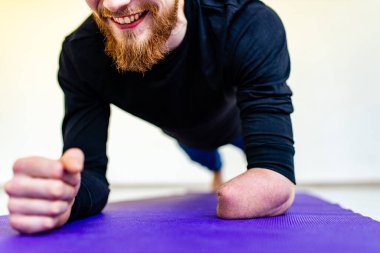 Yakışıklı adam ısınıyor ve evde antrenman yapıyor.