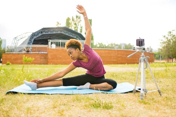 Happy mexican woman sport blogger with camera on tripod recording outdoor fitness training — Stock Photo, Image
