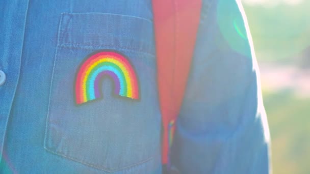 Chica de mezclilla camiseta con símbolo del arco iris llevar mochila en el parque de verano al aire libre. — Vídeo de stock