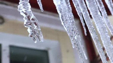 Rusya 'nın kış günü çatıda sallanan buz sarkıtları