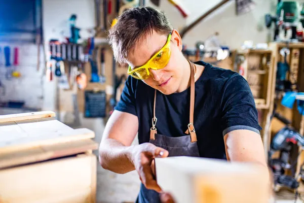 Timmerman jong werkend met hout in werkplaats — Stockfoto