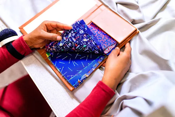 Африканская американская портниха работает с цветовыми образцами для выбора новой коллекции одежды — стоковое фото
