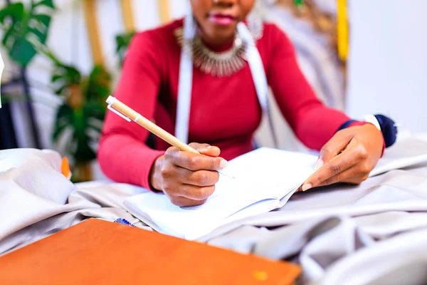 Tanzanian kvinna med orm print turban över höra arbetar i mode hus — Stockfoto