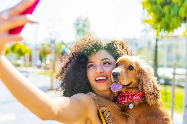 Brasilianerin und süßer Hund verspüren Fernweh bei sonnigem Tag und machen Selfie mit Smartphone-Kamera — Stockfoto