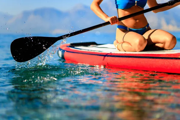 Woman sitting on sup board and enjoying peace and quiet outdoors — Stock Photo, Image