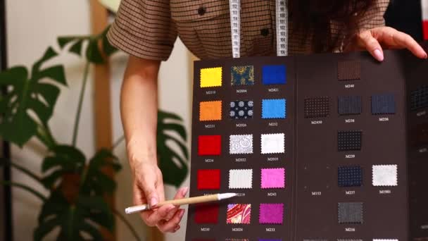 Плаття жінка працює з кольоровими зразками для вибору нової колекції одягу — стокове відео