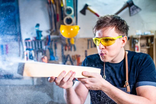 Portret van knappe timmerman werkend met plank in werkplaats — Stockfoto
