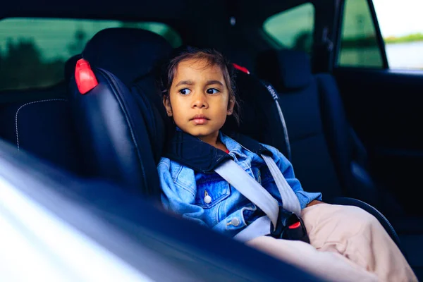 Menina de raça mista no assento do carro com cinto apertado — Fotografia de Stock