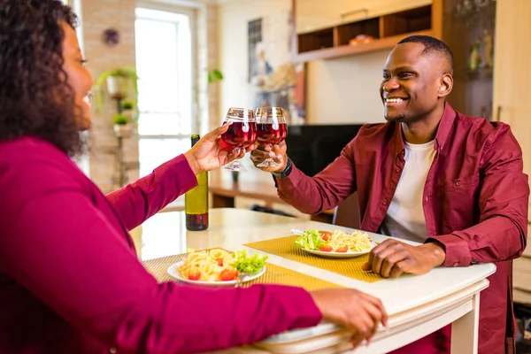 Афроамериканське подружжя любить пити вино з окулярів і їсти італійське макарони у вітальні 14 лютого валентинки. — стокове фото