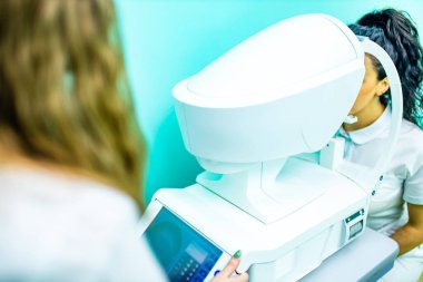 Optometrist laboratuarındaki Arap hasta görme ve görme düzeltmelerini kontrol ediyor.