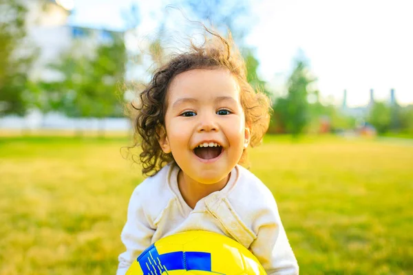 Afro american little girl with curly hair playing ball outdoors — Stock Photo, Image