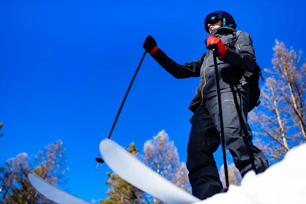 Mannelijke skiër het dragen van ski googles masker en professionele uitrusting ski 's ourdoors in russisch bos — Stockfoto