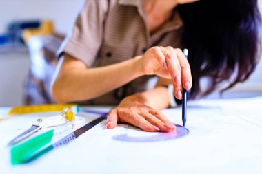 Ev stüdyodaki çalışma masasında çalışan terzi.