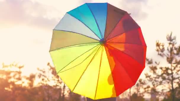 Frau hält Regenbogenschirm im Freien zurück — Stockvideo