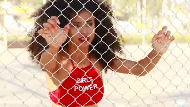 Hermosa mujer de raza mixta en sujetador rojo con inscripciones niñas poder detrás de la pared de celosía — Vídeos de Stock