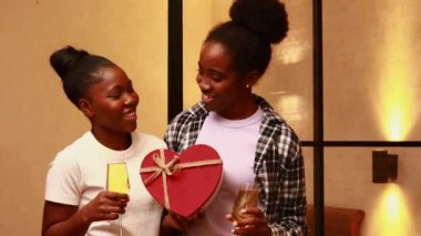 Mutlu Latin kadın sevgililer günü hediyesi yapıyor. Evdeki sevgili kız arkadaşına. Kadeh kaldırma şampuanı yapıyor.