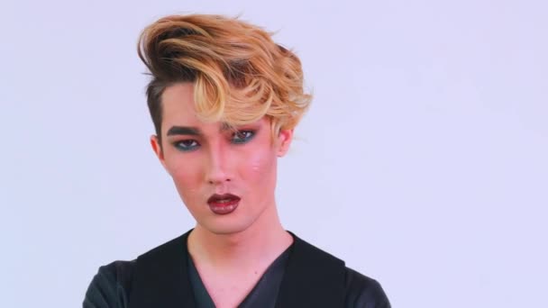 Asian man with luxurious blonde hair and gorgeous make-up in white wall studio background passion look at camera — Stock Video