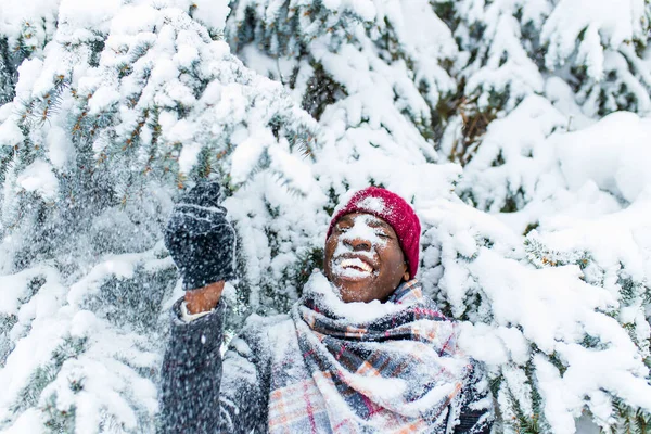 Afrykański amerykański handsom mężczyzna w czerwonym kapeluszu i stylowy płaszcz w kratę patrzeć przed kamerą z zęba śnieżnobiały uśmiech zewnątrz w parku — Zdjęcie stockowe