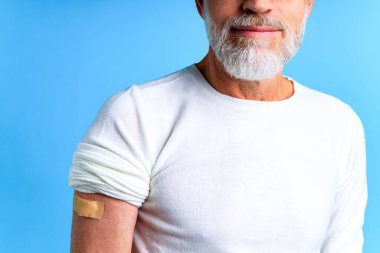 Sağlıklı, olgun bir adam bağışıklık sistemi için mavi arka plan stüdyosu yaptırıyor.