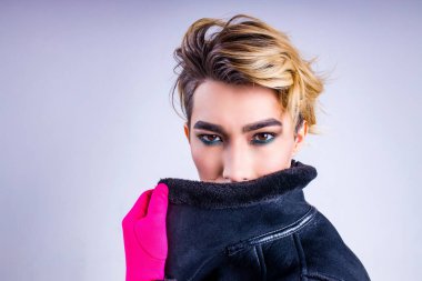 Stüdyonun beyaz arka planında kendine güveni ve özgüveniyle kendine güvenen şık moda adamının portresi.