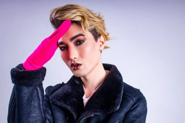 Stüdyonun beyaz arka planında kendine güveni ve özgüveniyle kendine güvenen şık moda adamının portresi.