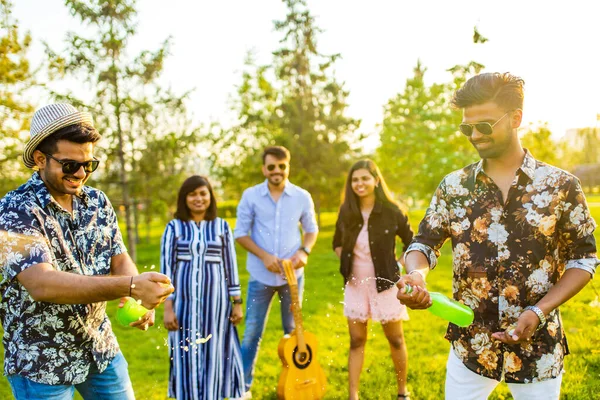 Pakistani felici migliori amici che festeggiano con limonata e birra nel parco estivo — Foto Stock