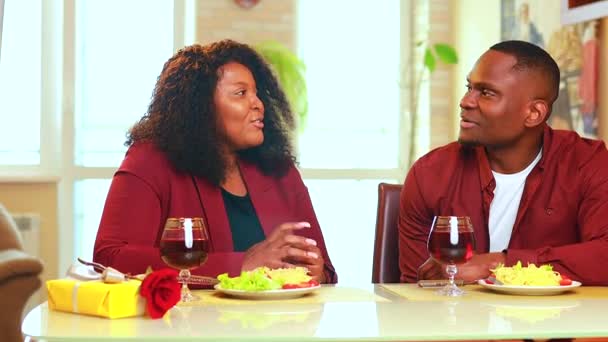 Africký americký pár v lásce pití vína z brýlí a jíst italské těstoviny v obývacím pokoji 14 únor Valentines den — Stock video