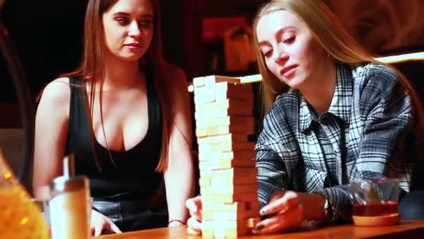 Молодые люди весело играют в настольные игры за столом в кафе — стоковое видео