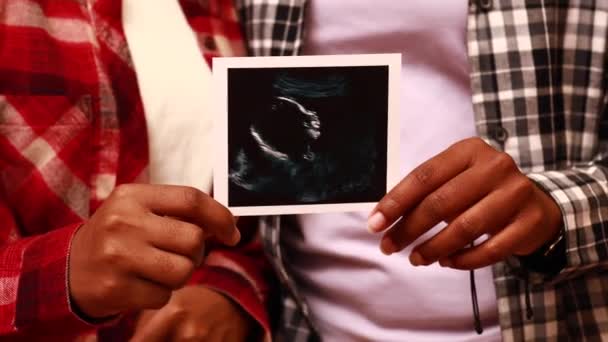 African american two happy future mothers sonogram image at home in evening — Stock video