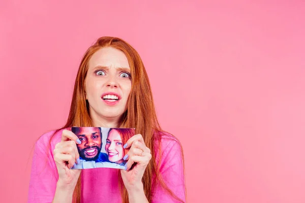 Pelirroja jengibre triste mujer rasgando foto de feliz pareja internacional — Foto de Stock