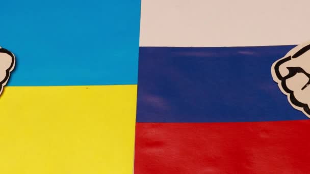 俄罗斯和乌克兰国旗上的两个硬纸板拳头。俄罗斯与乌克兰之间的第三次世界大战争端和冲突政策概念 — 图库视频影像
