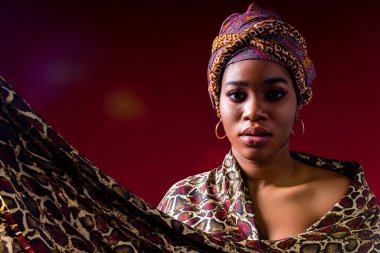 Zanzibar kadın kırmızı stüdyo arka planında başlık takıyor.