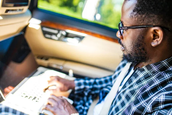 Yakışıklı sakallı adam yeni arabasında rahatça oturuyor.