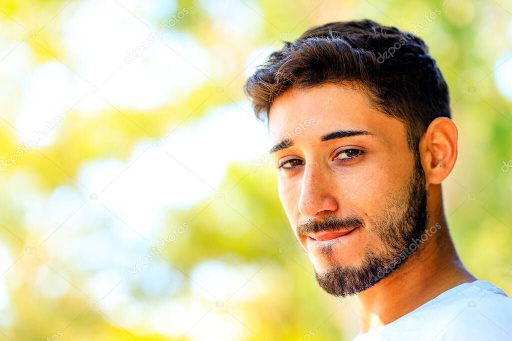 Handsome bearded man in white shirt with brown eyes outdoors