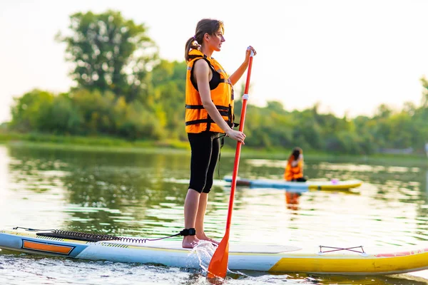 Frau in Schwimmweste am U-Boot am Abend, Waldbäume im Hintergrund — Stockfoto