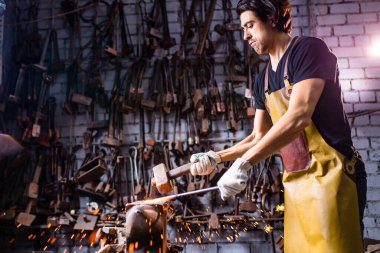 İtalyan esmer erkek nalbant atölyede çalışıyor.