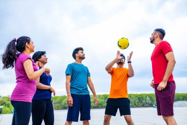 Çok ırklı takım plaj voleybolu oynuyor..