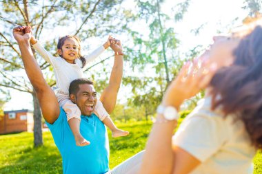 Parkta çimlerin üzerinde bebeği olan bir aile otantik duygular.