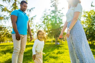 Latin baba ve Avrupalı anne güneşli bir günde piknikte sevimli bir çocukla .