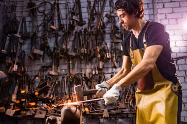 Leaáapron çekiç endüstrisindeki otantik yakışıklı Hintli adam. Küçük işletme. .