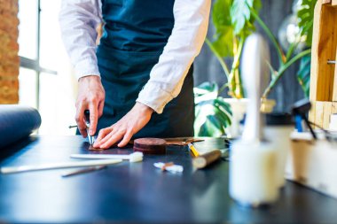 Yetenekli ayakkabıcılar atölyede deri ayakkabılar yaparlar. .