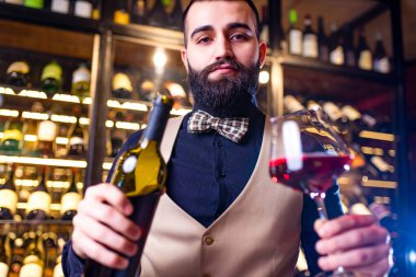 Otantik insanlar mutlu erkek şarap üreticisi bir tat alıyor ve kırmızı şarap kalitesini kontrol ediyor. .