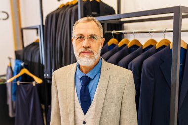 şık ve zengin takım elbiseli yaşlı yakışıklı adam atölyenin sahibi işiyle meşgul..