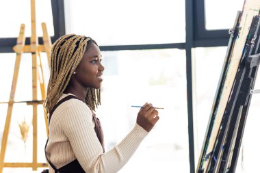 Sanat atölyesinde burun piercingli Afrikalı genç bir öğrenci..