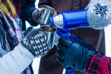 Mutlu genç Hintli arkadaşlar sıcak çayla ısınır. .