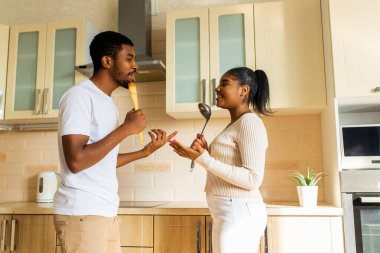 İspanyol çift mutfakta mikrofon gibi bir kepçeyle birlikte şarkı söylüyor..