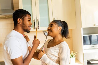 İspanyol çift mutfakta mikrofon gibi bir kepçeyle birlikte şarkı söylüyor..