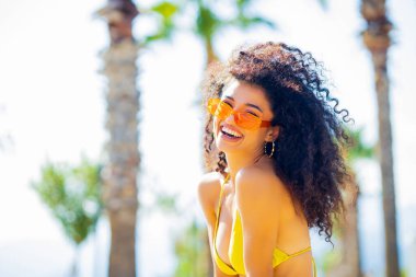 Uzun kıvırcık saçlı çok kültürlü bir kadın kendini güçlü ve korkusuz hissediyor..